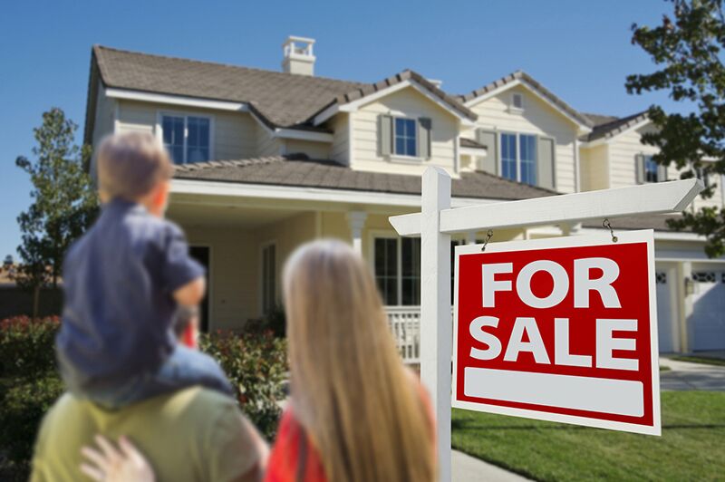 family walking toward house with for sale sign in front