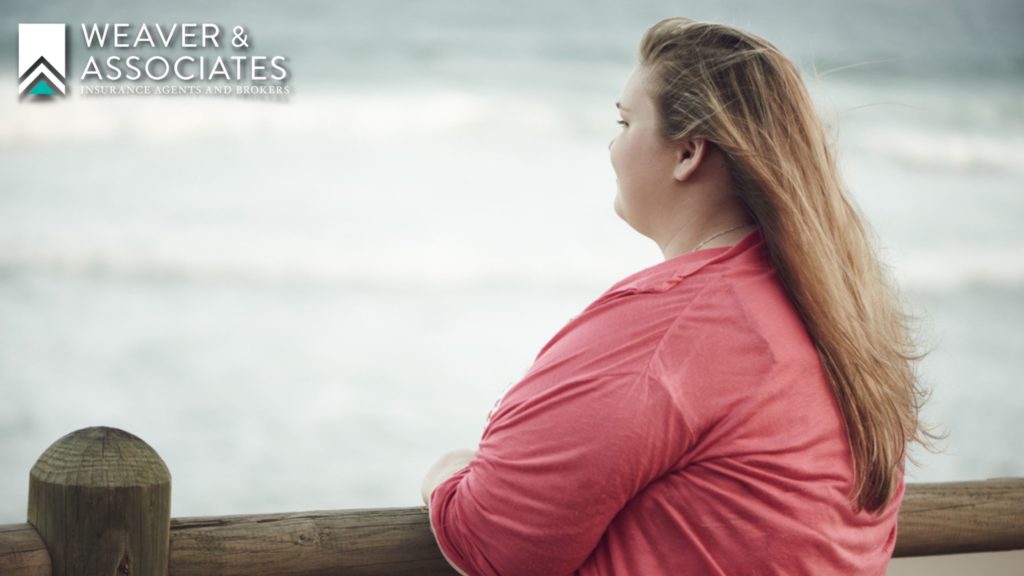 Overweight woman thinking alone about her life insurance